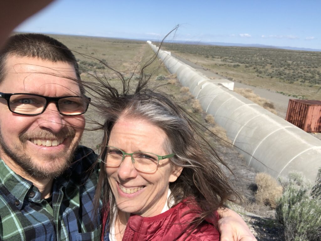 Arlene and Gregory standing in front of one of the 2.5 miles arms of LIGO.