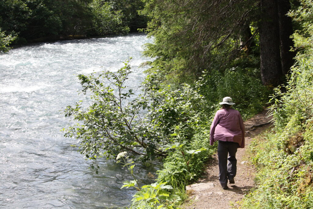 Arlene walking away on a path near a stream.